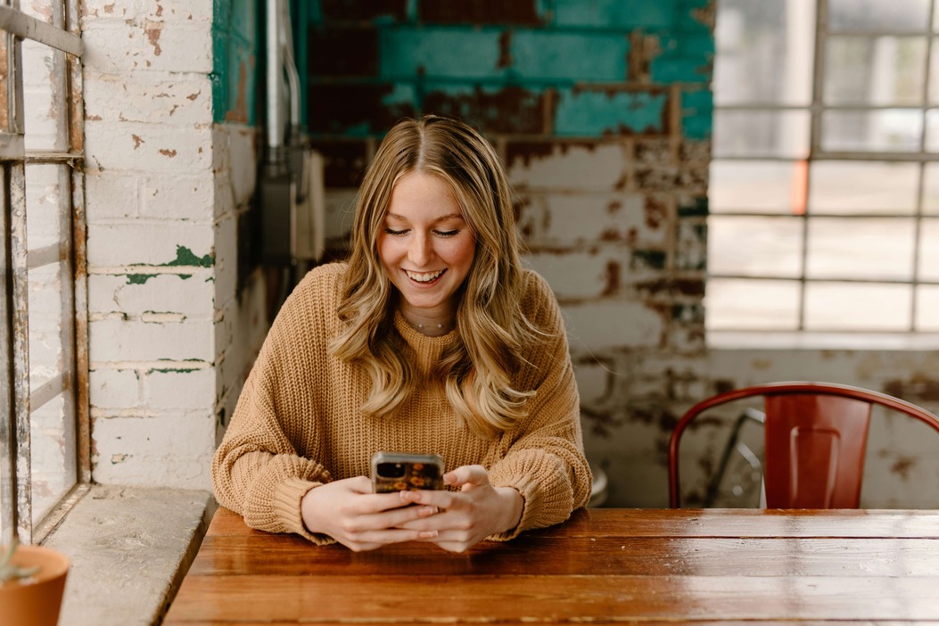 A candidate smiling while completing her onboarding on her phone