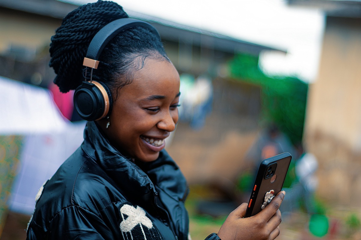 A candidate smiling while checking her bookings on her phone